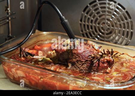 Gros plan de délicieux rôti de bœuf avec du rosmary et des légumes au four avec thermomètre Banque D'Images