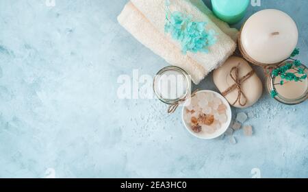 Ensemble spa avec produits de soin sur fond bleu pâle. Vue latérale, panorama. Banque D'Images