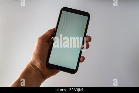 Femme tient la main d'un smartphone blanc à écran cassé. Main montrant le nouveau smartphone avec écran vide Banque D'Images