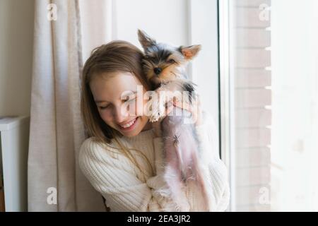 Jeune femme jouant avec le chien le week-end à la maison. Joyeux chien terrier du yorkshire Banque D'Images