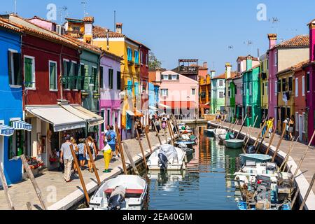 Burano, Italie, 2020 septembre – les touristes se baladent le long d'un canal typique de Burano avec des maisons colorées et une boutique de cadeaux Banque D'Images