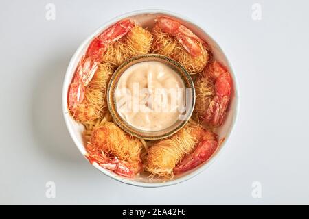 Vue aérienne d'un cube de crevettes frites enveloppées de pâtes Kataifi et servies avec une sauce dragon. Banque D'Images