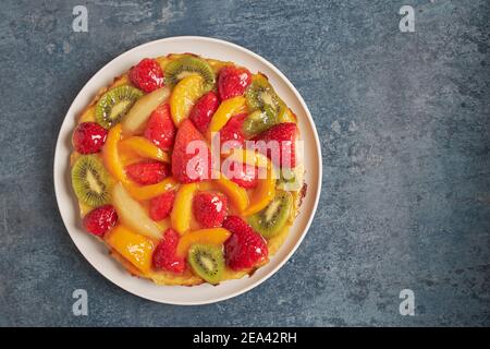 Vue aérienne d'une délicieuse tarte aux fruits de saison frais et à la crème. Banque D'Images