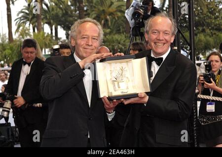 Les réalisateurs belges, les frères Luc Dardenne (R) et Jean-Pierre Dardenne montrent le trophée Palme d'Or qu'ils ont remporté samedi pour leur film 'l'enfant', alors qu'ils arrivent sur le tapis rouge pour la cérémonie de clôture du 58e Festival international du film de Cannes, dans le sud de la France, le 22 mai 2005. Photo de Hahn-Nebinger-Klein/ABACA Banque D'Images