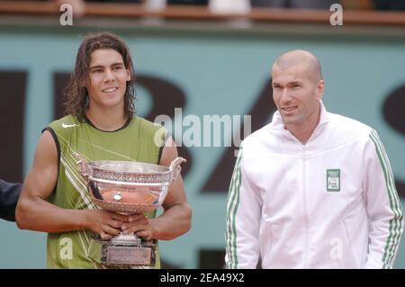 Zinedine Zidane, joueur de football français, présente le trophée au gagnant Espagne Rafael Nadal (6-7, 6-1, 6-4, 7-5) contre Mariano Puerta, Argentine, lors de l'ouverture du tennis français à l'arène Roland Garros, à Paris, le 5 juin 2005. Photo de Gorassini-Zabulon/CAMELEON/ABACA. Banque D'Images