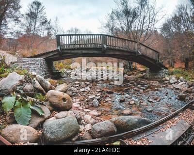 Photo extérieure d'un pont en bois au-dessus de la petite eau flux Banque D'Images
