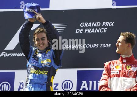 Fernando Alonso, de Renault, d'Espagne, à côté de Michael Schumacher, réagit sur le podium après le Grand Prix de France au circuit Magny cours, dans le centre de la France, le 3 juillet 2005. Alonso a remporté la course devant Kimi Raikkonen de Finlande de McLaren en deuxième place et Michael Schumacher de Ferrari en Allemagne qui a pris la troisième place. Photo de Thierry Gromik/ABACAPRESS.COM Banque D'Images