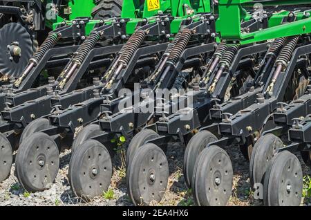 Semoir traîné préparé pour les travaux saisonniers futurs et installé pour remisage hivernal au stationnement du tracteur d'une ferme individuelle Banque D'Images