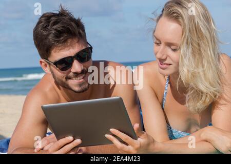 Couple à l'aide d'électronique, d'un lac Banque D'Images