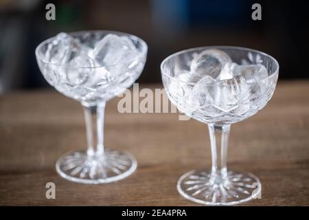 Deux verres à cocktail ornementaux sont refroidis avec des cubes de glace en eux. Banque D'Images