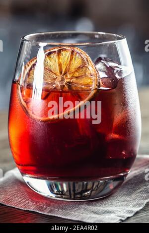 Cocktail classique Negroni et boisson courte au gin avec vermouth doux, liqueur rouge amère et garniture d'orange séchée. Banque D'Images