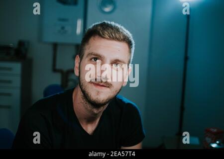 Un portrait d'un homme souriant avec une barbe et une courte coupe de cheveux sur l'arrière-plan flou Banque D'Images