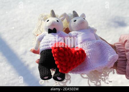 Histoire d'amour pour la Saint Valentin sur fond blanc, coeur rouge entre les mains comme symbole de l'amour Banque D'Images