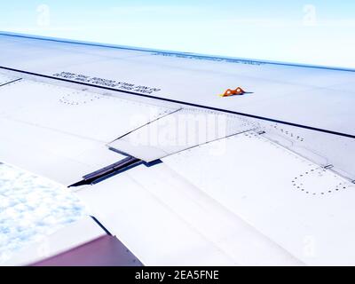 Petit crochet jaune sur l'aile de l'avion, vue de la fenêtre en volant au-dessus du nuage. La fonction cachée sur les ailes de l'avion qui pourrait vous sauver la vie Banque D'Images