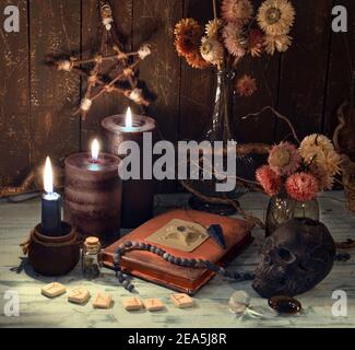 Vintage encore la vie avec vieux livre de journal, bougies en feu, fleurs sèches et runes. Arrière-plan ésotérique, gothique et occulte, concept mystique d'Halloween. Banque D'Images