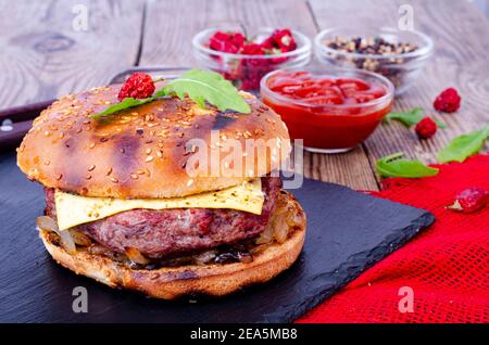 Hamburger maison avec pain au sésame et bœuf haché sur le noir pierre Banque D'Images