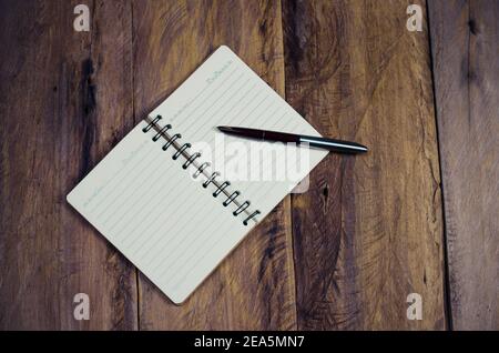 bloc-notes vierge avec stylo sur table en bois - durée de vie fixe Banque D'Images