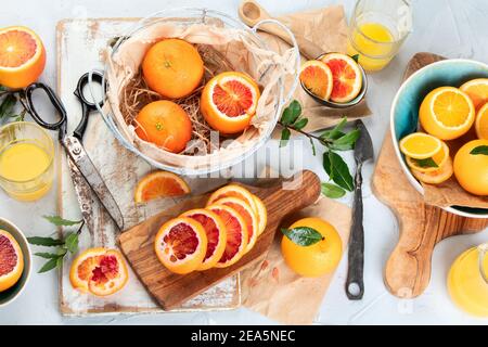 Oranges avec feuilles dans le panier, jus d'orange sur fond clair. Vue de dessus Banque D'Images