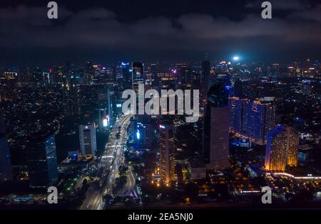 Centre-ville moderne avec gratte-ciel à la nuit des lumières de la ville et la circulation sur l'autoroute à Jakarta, Indonésie dans le noir Banque D'Images