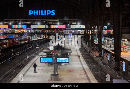 Hambourg, Allemagne. 08 février 2021. Un homme portant un masque de protection traverse une plate-forme à la gare centrale de Hambourg. Une lourde tempête de neige a causé le chaos de la circulation dans certaines parties de l'Allemagne. Les chemins de fer ont subi des restrictions importantes dans le trafic régional et le trafic longue distance. Credit: Georg Wendt/dpa/Alay Live News Banque D'Images