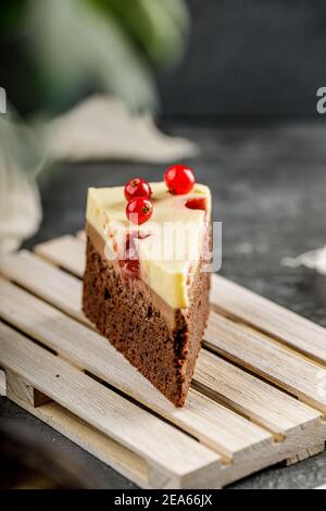 Gros plan d'une tranche de délicieux gâteau avec du cassis et de la crème fouettée à la guesy. Cheesecake savoureux Banque D'Images