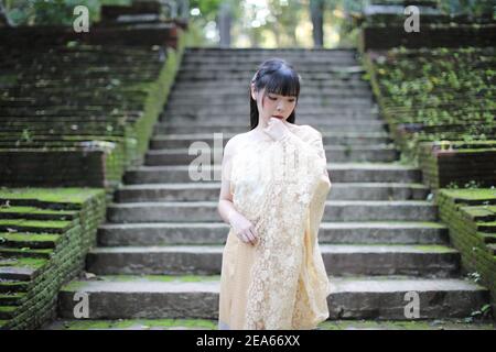 Portrait de la femme thaïlandaise avec robe traditionnelle thaïlandaise avec temple arrière-plan Banque D'Images