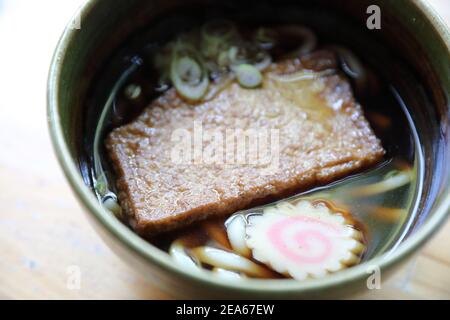 nouilles au udon de kitsune avec boule de poisson et tofu sur bois arrière-plan cuisine japonaise Banque D'Images