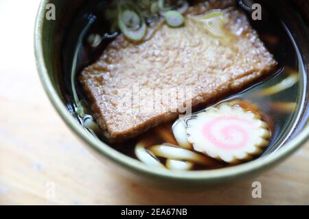 nouilles au udon de kitsune avec boule de poisson et tofu sur bois arrière-plan cuisine japonaise Banque D'Images