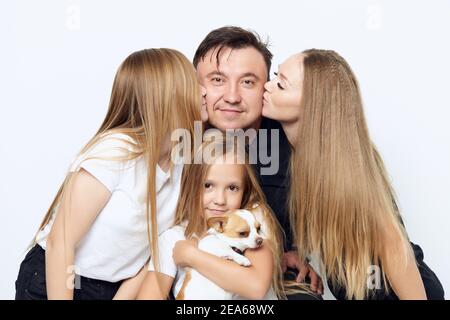 maman avec fille embrassant père fille avec chien dans elle gros plan sur la photo de famille arms Banque D'Images