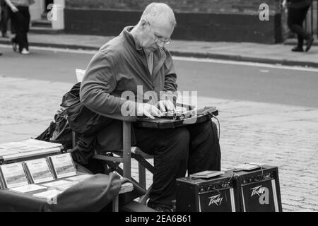 Un homme s'est assis derrière deux haut-parleurs à York, jouant une autoharpe. North Yorkshire, Angleterre, Royaume-Uni. Banque D'Images