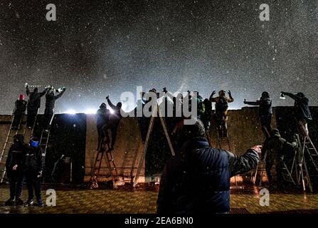 Prague, République tchèque. 6 février 2021. Les fans, debout sur des échelles derrière la clôture, regardent un match de la première division tchèque entre Bohemians Prague et le FC Zbrojovka Brno à Prague, République Tchèque, le samedi 6 février 2021. Parmi les mesures restrictives qui limitent le nombre de fans de football à assister au match, les fans recherchent des moyens novateurs de regarder le match pendant la pandémie du coronavirus. Crédit : Roman Vondrous/CTK photo/Alay Live News Banque D'Images