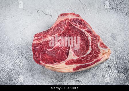 Un steak de cowboy brut ou un œil de côtes sur l'os. Bœuf en marbre. Arrière-plan gris. Vue de dessus Banque D'Images