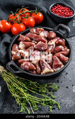 Cœurs de poulet frais. Abats bruts. Arrière-plan noir. Vue de dessus Banque D'Images