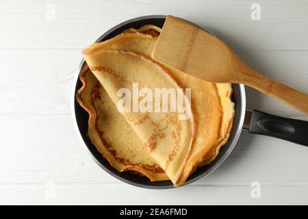 Faire une casserole avec de savoureuses crêpes fines et une spatule sur une table en bois Banque D'Images