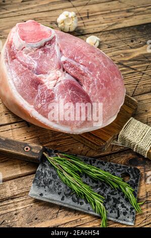 Jambon de porc cru coupé. Viande de jambe. Arrière-plan en bois. Vue de dessus Banque D'Images