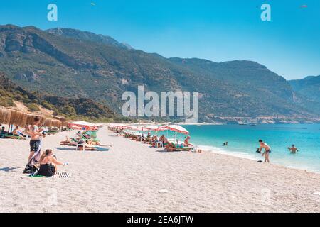 10 septembre 2020, Oludeniz, Turquie: Personnes se reposant et nageant sur des parasols et des chaises longues sur une plage publique populaire dans la station balnéaire Banque D'Images
