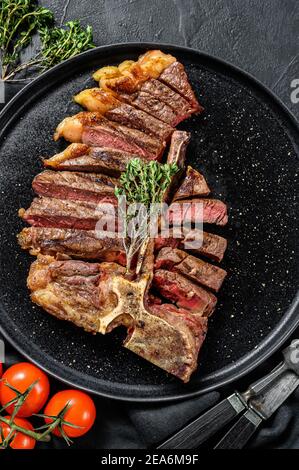 Steak de Porterhouse grillé sur une planche à découper. Viande de bœuf cuite. Fond en bois blanc. Vue de dessus Banque D'Images