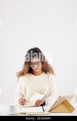 Femme d'affaires écrivant dans le planificateur Banque D'Images
