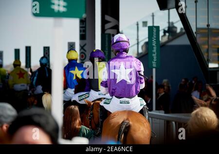 Les jockeys du Grand National se rendent à la ligne de départ de la course qui se tient chaque année à l'hippodrome d'Aintree, près de Liverpool, en Angleterre. Banque D'Images