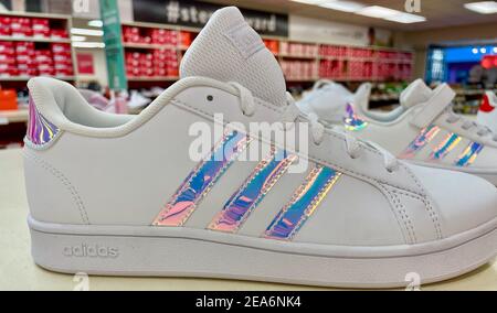 FRESNO, ÉTATS-UNIS - 05 févr. 2021 : une photo en gros plan des chaussures adidas blanches rayées à rayures irisées exposées en magasin Banque D'Images