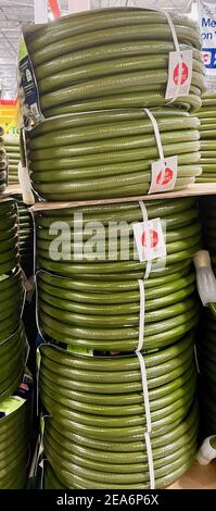 FRESNO, ÉTATS-UNIS - 05 févr. 2021: Une photo verticale des tuyaux de jardin roulés verts à Costco Banque D'Images