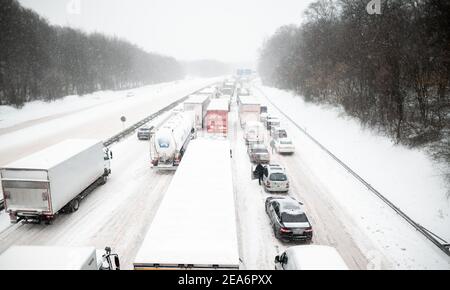 Oberhausen, Allemagne. 08 février 2021. Les véhicules sont bloqués dans un embouteillage sur l'autoroute A2/A3 à Kreuz Oberhausen. Les gens sortent de leur voiture et se tiennent sur l'autoroute. La forte chute de neige en Rhénanie-du-Nord-Westphalie cause de sévères restrictions de circulation. Credit: Fabian Strauch/dpa/Alay Live News Banque D'Images