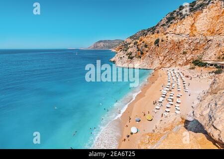 Une plage chic avec des chaises longues et des vacanciers. Vue de dessus du sable blanc et de l'eau azur riche Banque D'Images