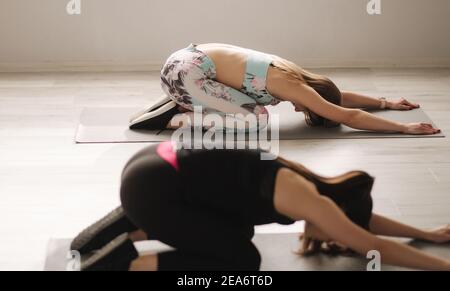 Groupe de jeune sportive attrayante femme pratiquant des pilates. Des personnes debout ensemble. Salle d'activité, pleine longueur, arrière-plan studio Banque D'Images