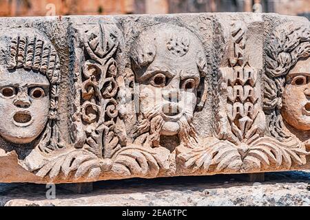 Bas relief avec des visages romains et grecs sculptés sur un Colonne de pierre dans l'ancienne ville de Myra en Turquie Près du village de Demre Banque D'Images