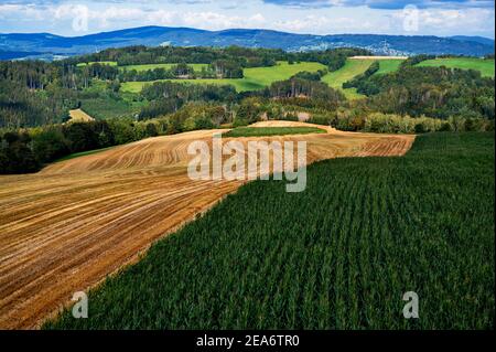 Champ labouré et vert, prairie, forêt, colline, collines et montagnes dans les contreforts de Krkonese près de Roprachtice, République Tchèque, vue aérienne. Banque D'Images