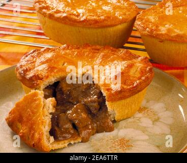 3 Steak pies une coupe ouverte montrant le remplissage de viande Banque D'Images