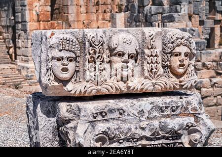 Bas relief avec des visages romains et grecs sculptés sur un Colonne de pierre dans l'ancienne ville de Myra en Turquie Près du village de Demre Banque D'Images