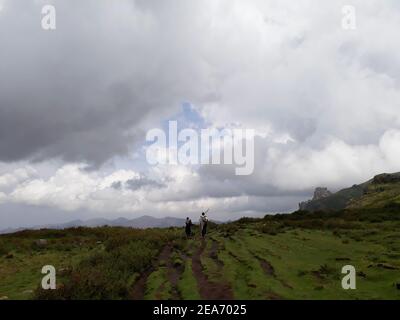 Lalibala-Ethipia - 10 avril 2019 : les hommes marchent dans le champ vert des montagnes éthiopiennes Banque D'Images