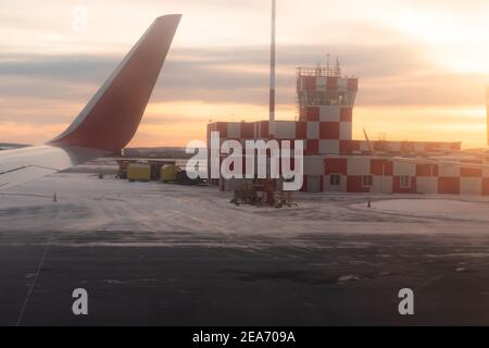 bâtiment de l'aéroport à l'aube sur la piste avec feu à éclats peint en carreaux rouges et blancs. vue sur la fenêtre de l'avion Banque D'Images